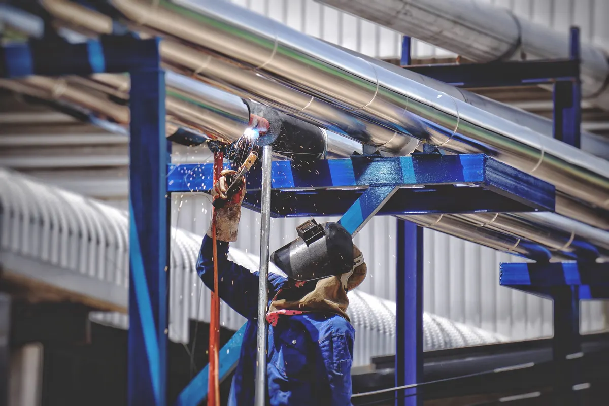 Profissional executando soldagem em tubulações industriais
